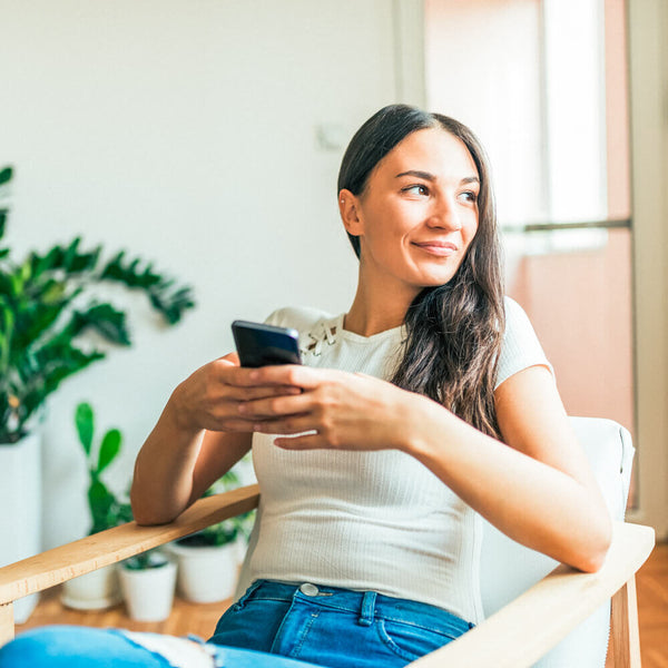 Sprinkle Club - A woman on her phone using the Later instagram scheduling app to access a bank of hashtags