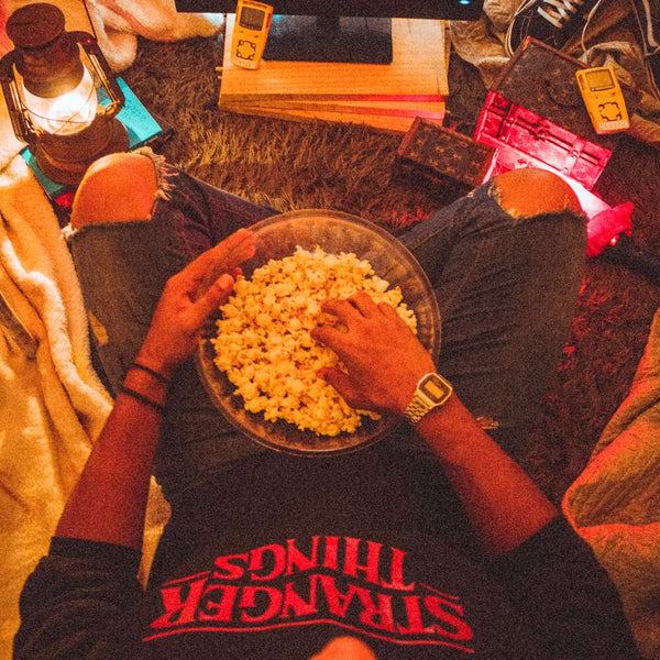 Sprinkle Club - Someone cosy at home having a movie marathon while eating popcorn and snacks