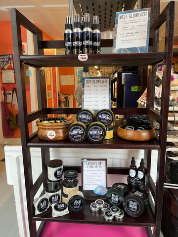 Natural skin care products, including turmeric lotion and toner, displayed on a wooden shelf.