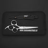 double swivel hair cutting scissor and black razor lying on black leather pouch