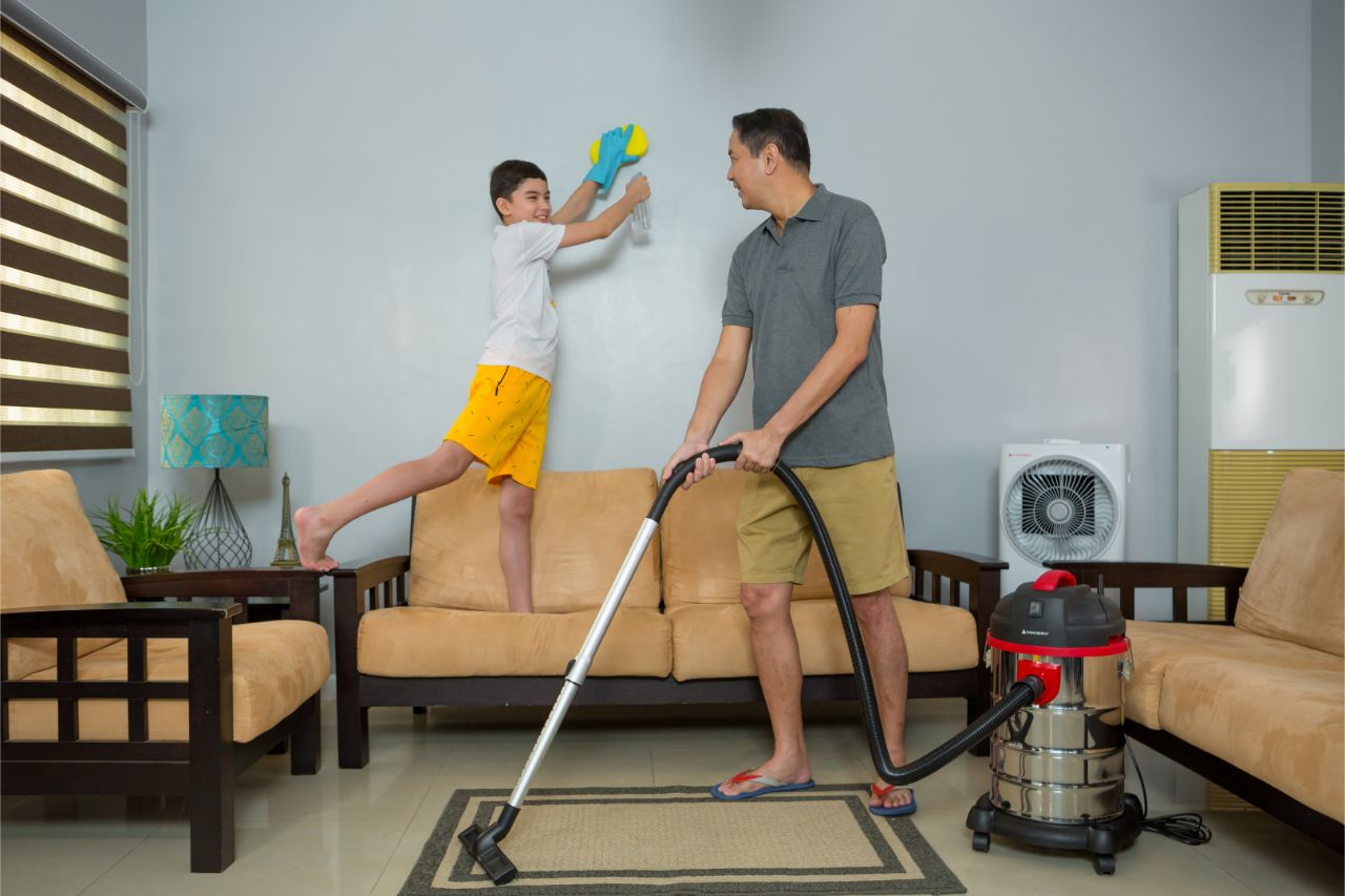 Father and son cleaning the living room