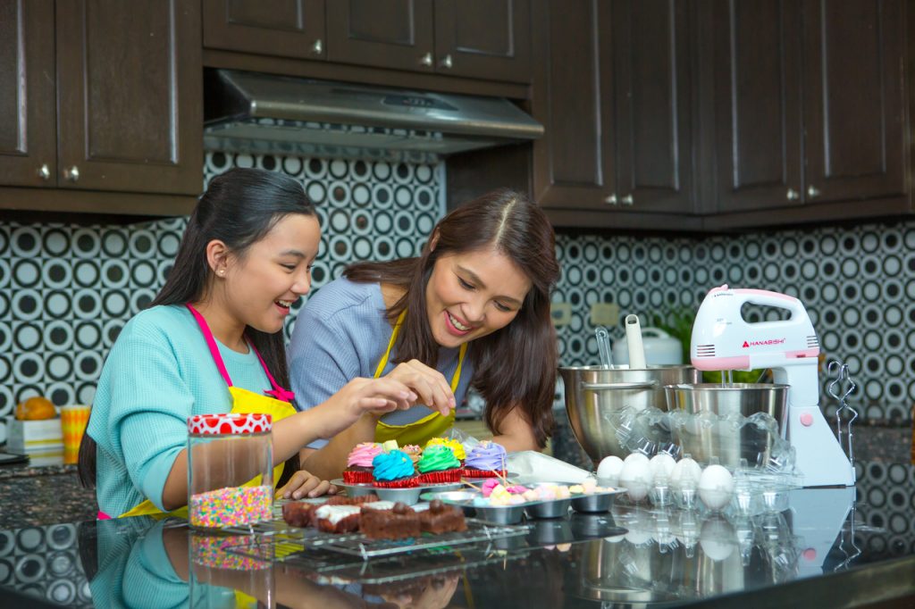 A mother and daughter baking cupcakes