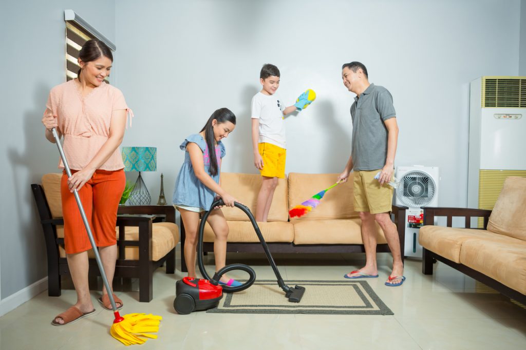 A whole family cleaning their living room