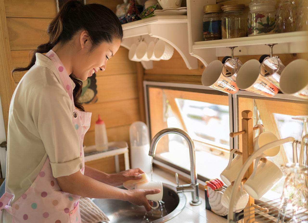 An Asian mother happily cleaning the dishes