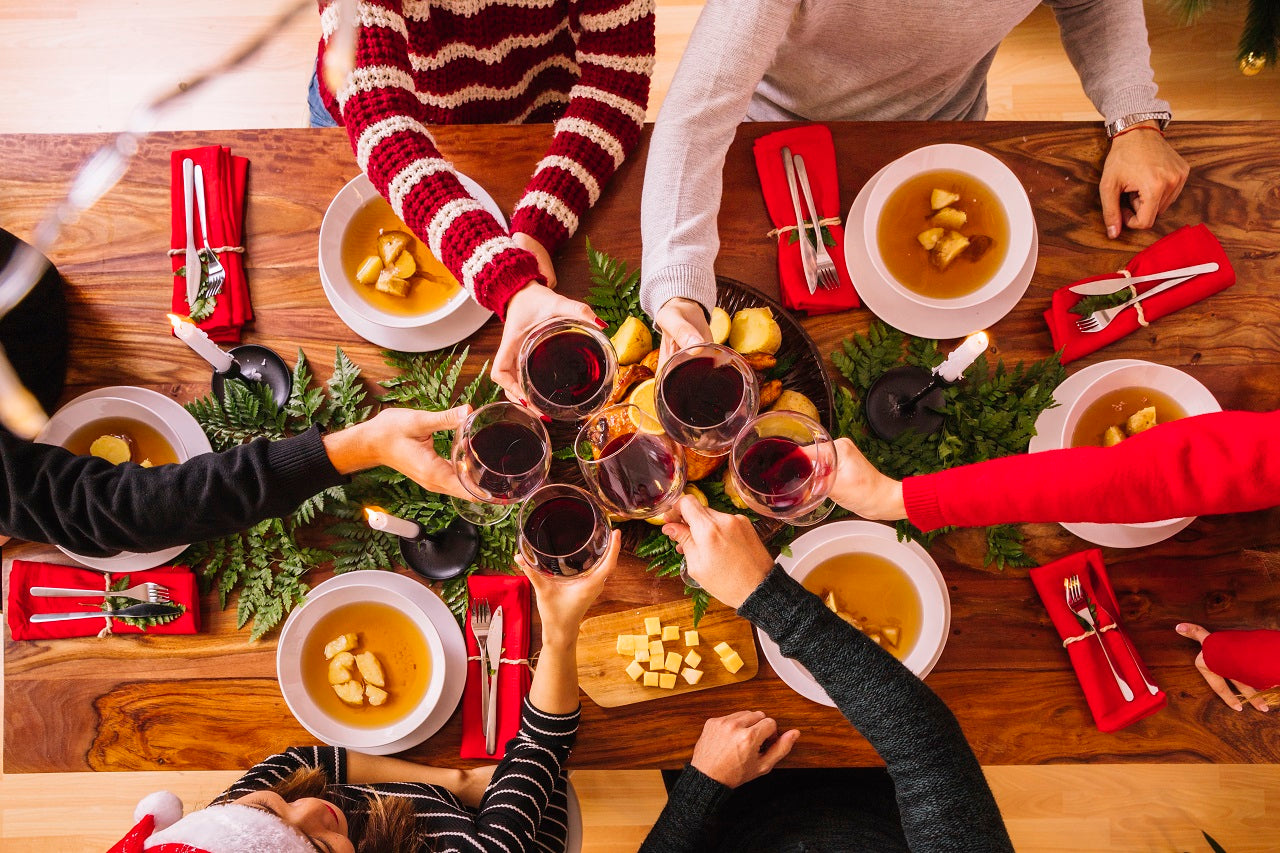 A group of people saying cheers while having a Christmas meal