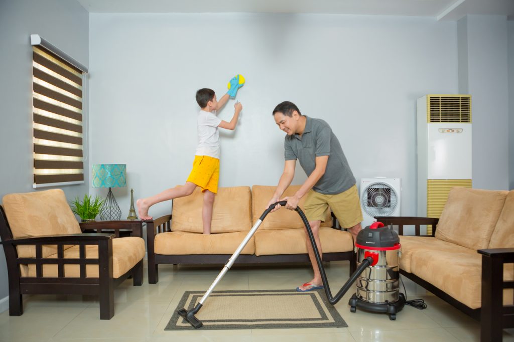 A father and son cleaning the living room