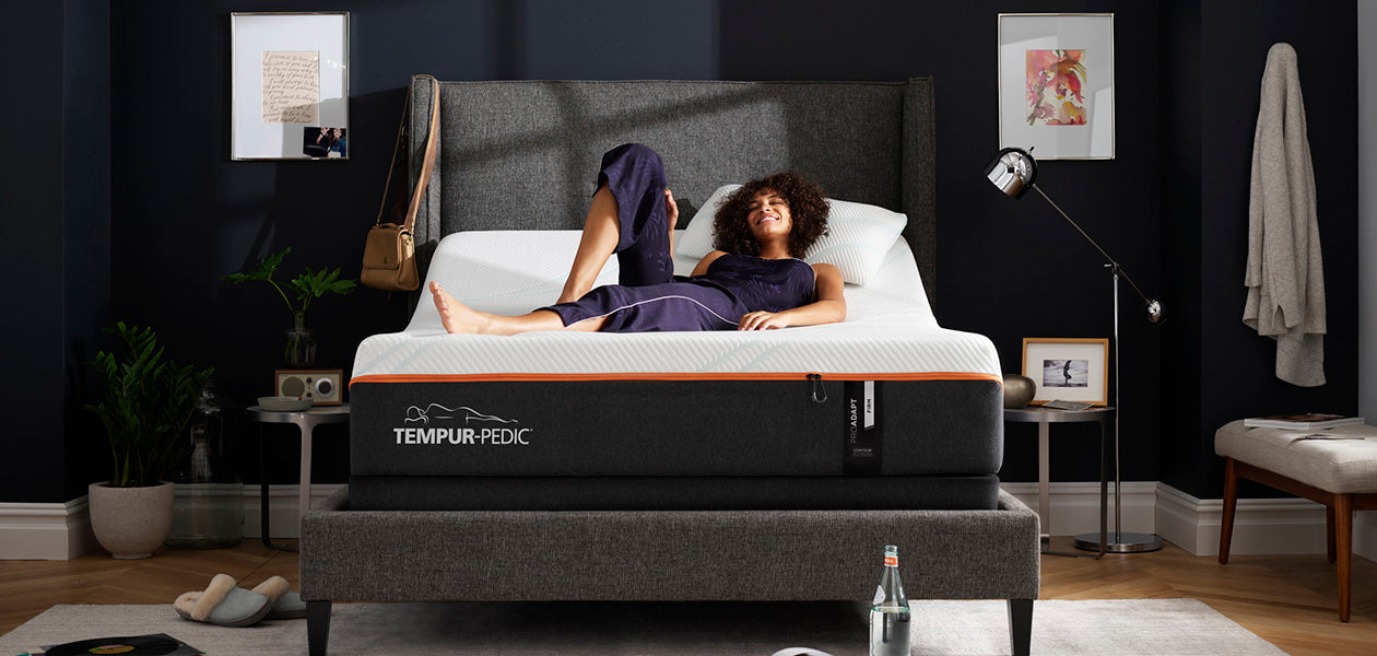 Woman lounging on a Pro Adapt Firm mattress that's on an adjustable base with the head tilted up