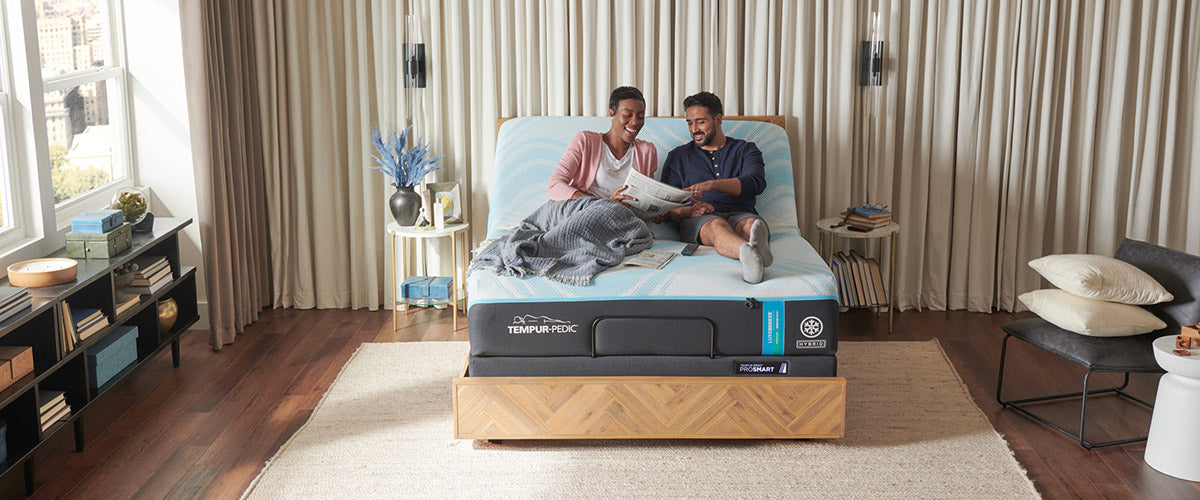 Couple laying on a Tempur-Pedic mattress that's on an adjustable base with the head raised up