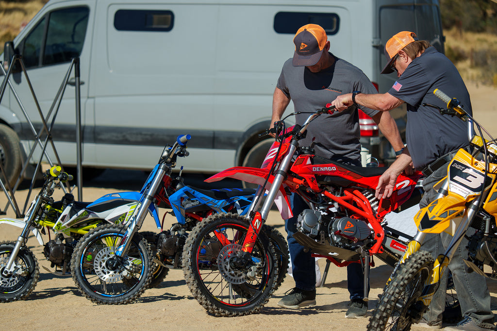 Two people checking on the Denago Powersports MX2 Dirt Bike
