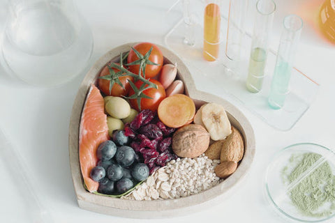 a heart shaped bowl with fruits and foods