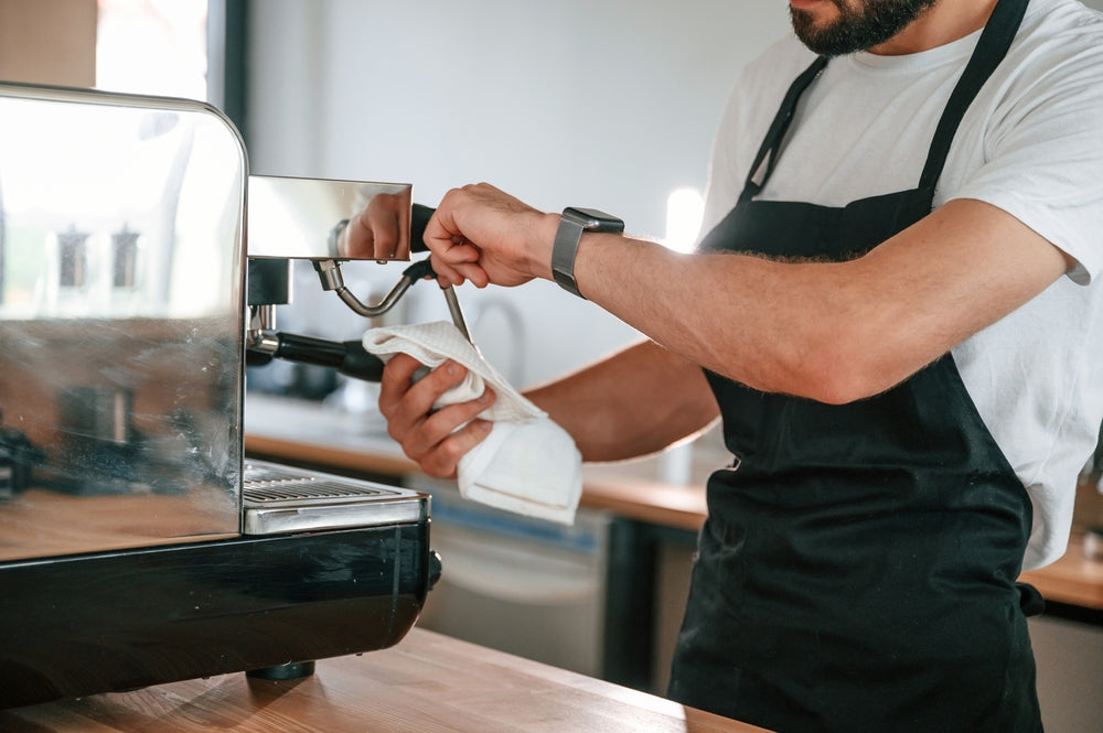 a barista cleaning coffee machine