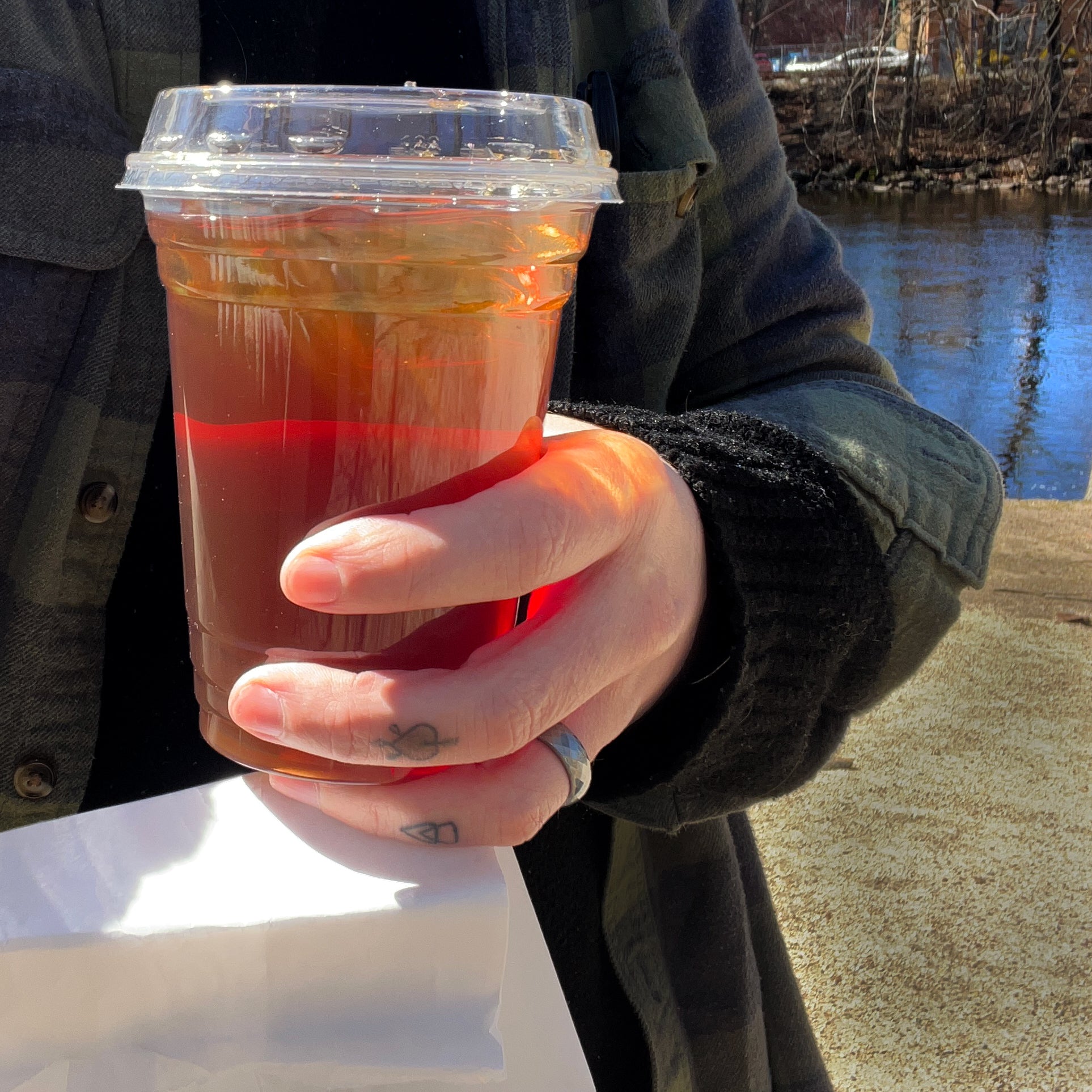 Delicious and refreshing iced being held by Ian by the Charles River