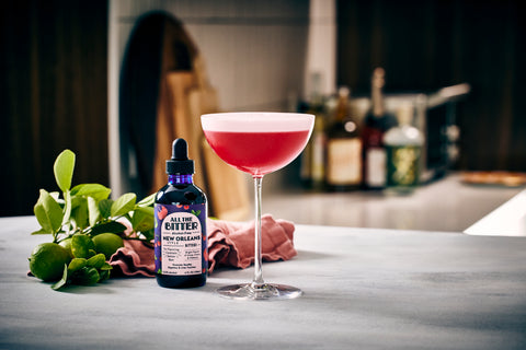 hibiscus sour non-alcoholic cocktail with bottle of bitters