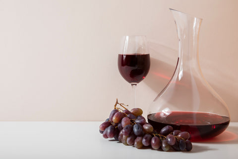 non-alcoholic red wine and a carafe with grapes