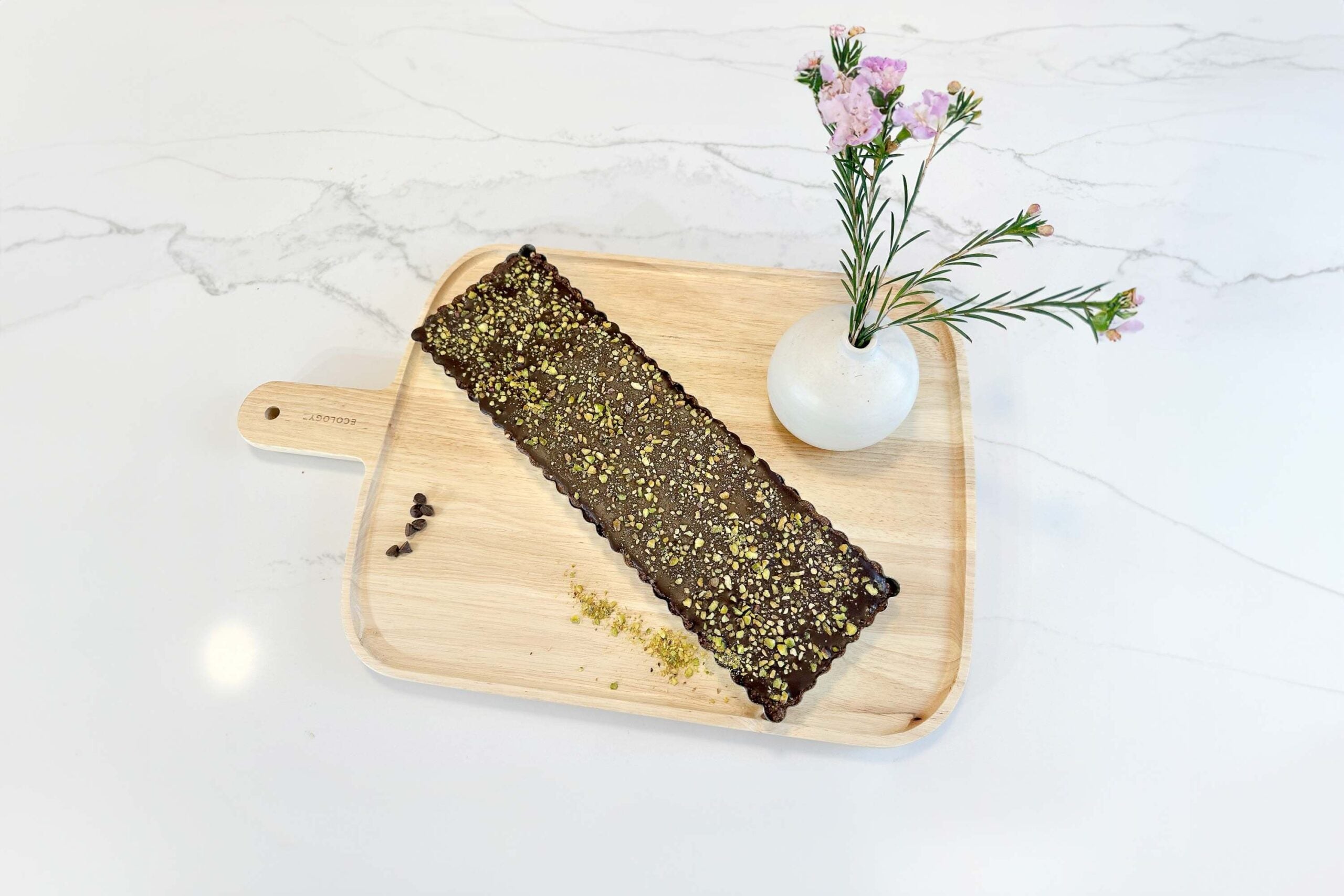 seed cycle chocolate bar recipe on chopping board with vase and flowers