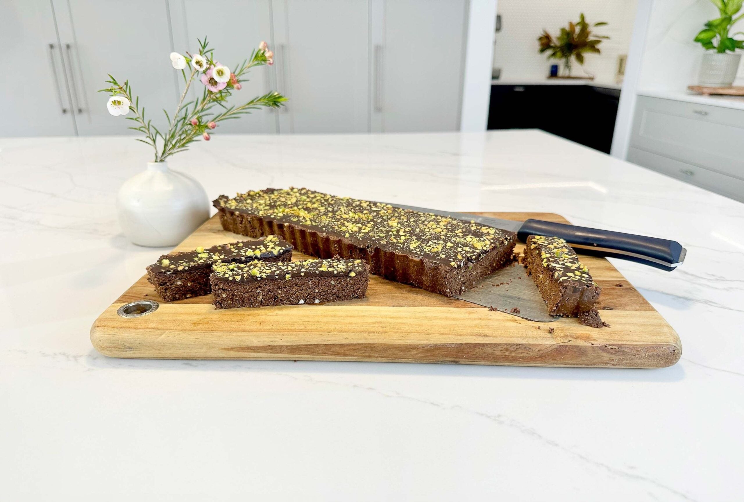 Seed Cycling chocolate bar recipe on kitchen bench with chopping board and knife visable