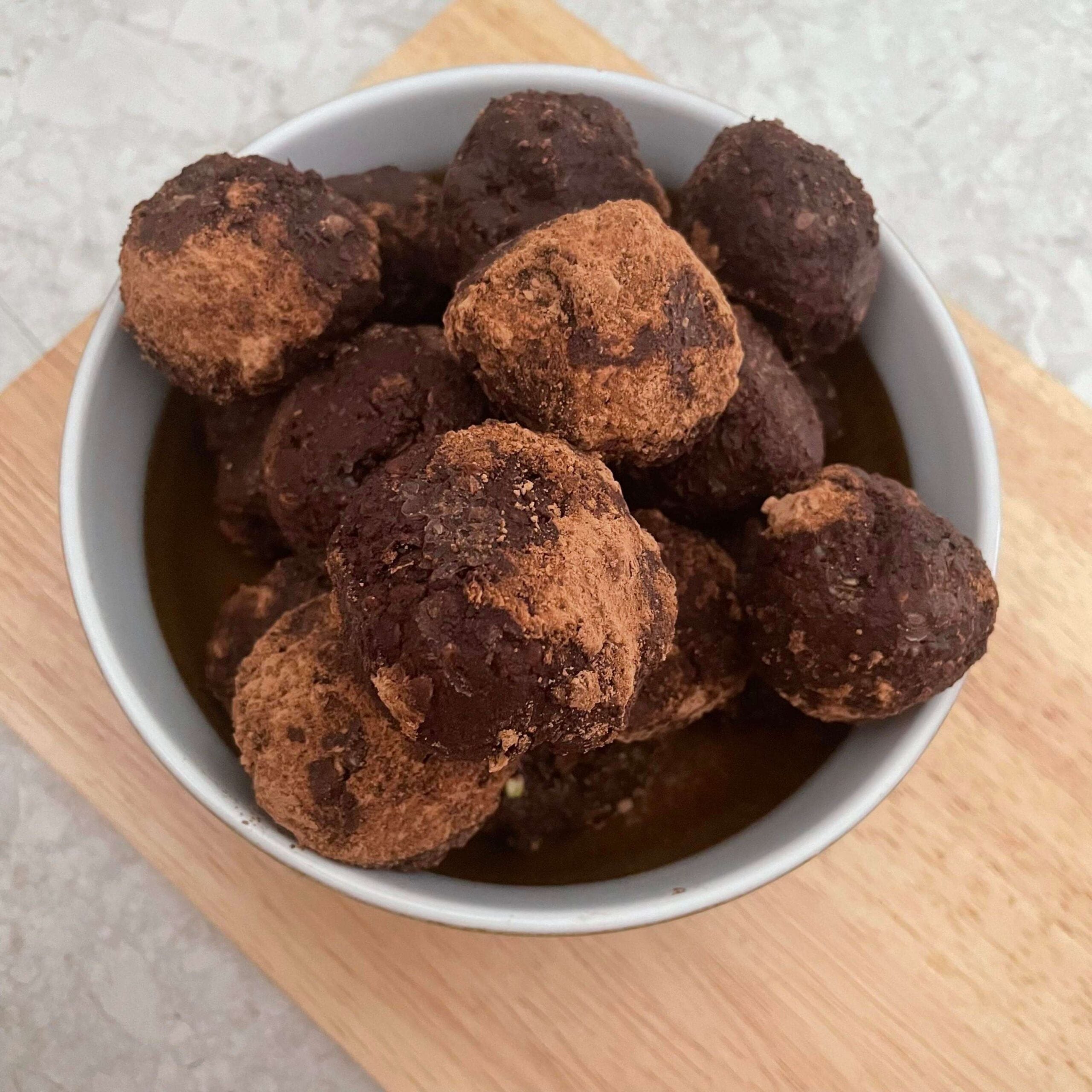 seed cycle vegan brownie bites in a bowl on timber chopping board