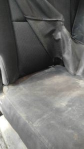 Construction truck with seat cover peeled back, showing the clean seat underneath