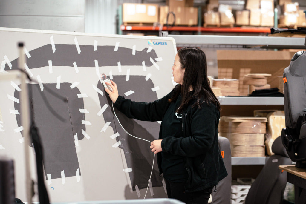 A woman digitizing a seat cover pattern so it can be put into the CAD system.