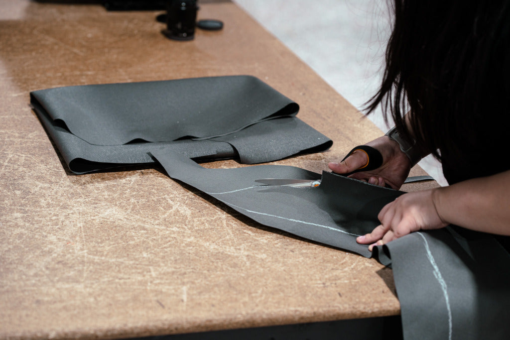Hands cutting a material for a prototype seat cover.