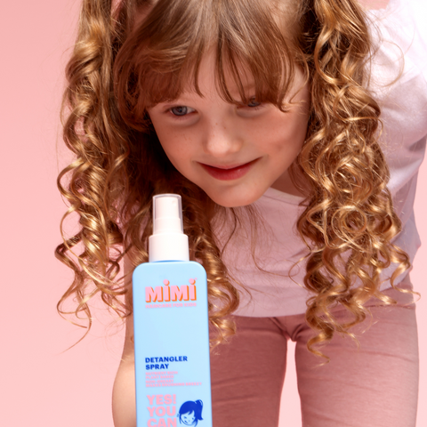 Girl holding blue cosmetic bottle, Mimi haircare for kids