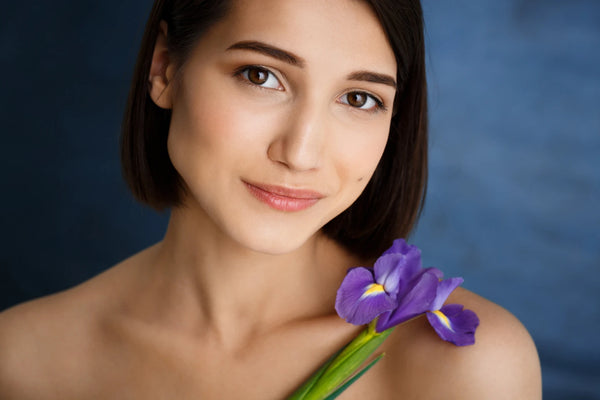 close-up-portrait-tender-young-woman-with-violet-flower-blue-wall