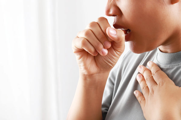 coughing-man-holding-fist-near-face-on-white-background