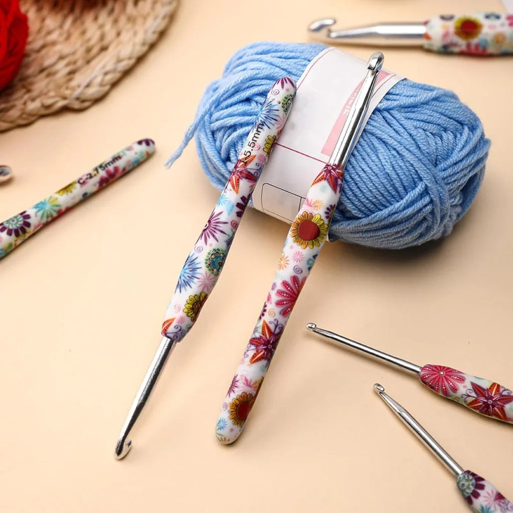 A 29-Piece Crocheting Kit: Perfect for Beginners, featuring blue yarn and ergonomic crochet hooks, is scattered on a beige surface.