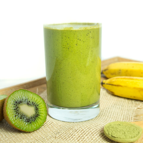 Green smoothie in glass with sliced kiwi. Get your veggies in with this good-for-you option.