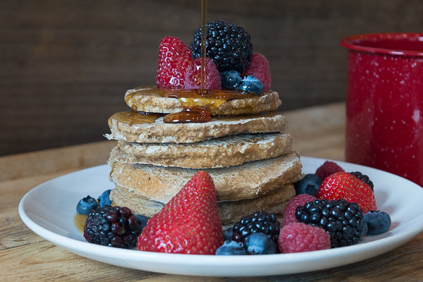 Whole grain oat pancakes with fresh berries and maple syrup. Easy, healthy breakfast recipe that's great for kids!