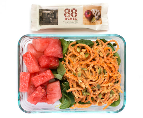 Spiralized carrots with pumpkin seed butter asian sauce, on bed of spinach with cubed watermelon and 88 Acres seed bar. Homemade recipe to send your kid for lunch. 