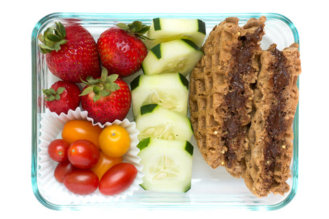 Whole-grain waffle sandwich with chocolate sunflower seed butter, sliced cucumbers, fresh strawberries, cherry tomatoes.