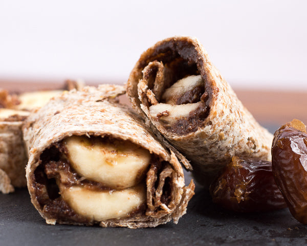 Sliced banana, dates, and dark chocolate sunflower seed butter wrapped in a tortilla. Healthy dessert option or fuel for student athletes.