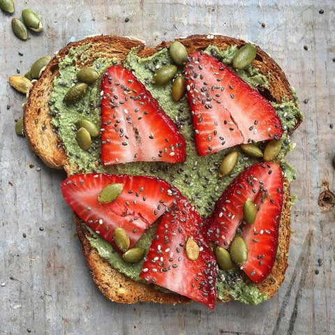 Toast spread with pumpkin seed butter, topped with sliced strawberries and pumpkin seeds. Easy way to get healthy fats in!