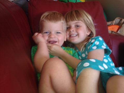 Siblings sitting on sofa