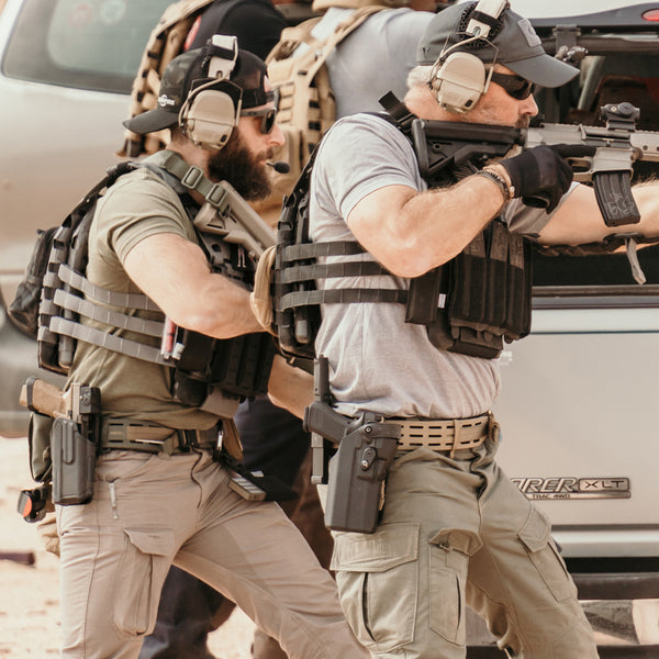Two shooters wearing ICEPLATE EXO plate carriers and gun belts.