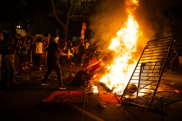 D.C. riots in reaction to George Floyd’s death. Rioters stand next to burning debris.