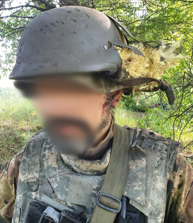 Ukrainian volunteer wears IOTV plate carrier in ACU camo pattern.