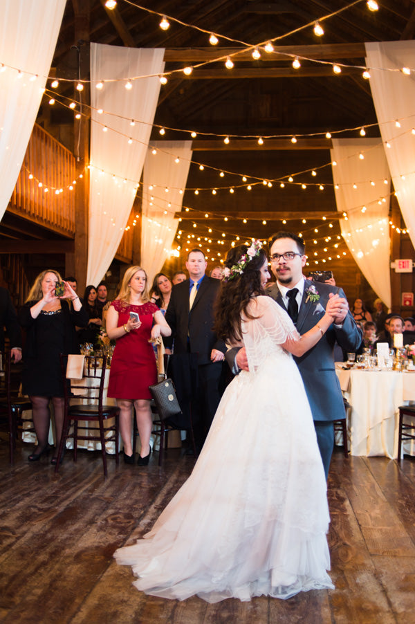 barn wedding bistro lights bride and groom first dance