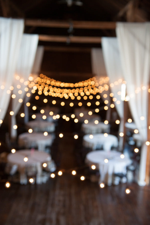 barn wedding reception with bistro lights and drapes