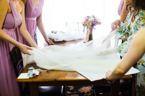 lavender bridesmaids dresses bride getting ready unwrapping veil