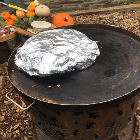 food wrapped in foil being cooked