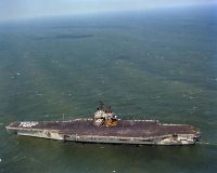 A port beam view of the aircraft carrier USS FORRESTAL (CV 59) with a formation of crewmen spelling out TGIF (Thank God It's Friday) on the flight deck. The carrier is returning to its home port at Mayport, Florida.<br>- 1989