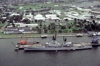 A port beam view of the guided missile cruiser USS WILLIAM H. STANDLEY (CG-32) docked at a pier. - 1981