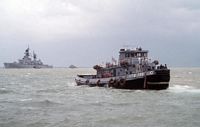 The large harbor tug OPELIKA (YTB 798) moves away from the guided missile cruiser USS WILLIAM H. STANDLEY (CG 32) as the aircraft carrier USS RANGER (CV 61) and its battle group enter the harbor. - 1989 - Naval Base Subic Bay PI