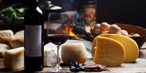 Rotweinflasche mit Käse im Hintergrund