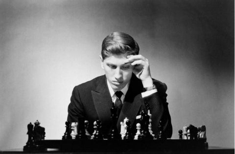 Bobby Fischer playing chess posing with chessboard and chess pieces