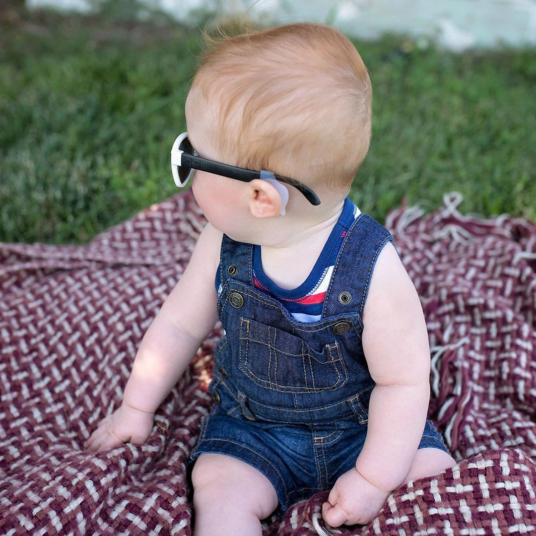 Child wearing glasses at picnic with head strap