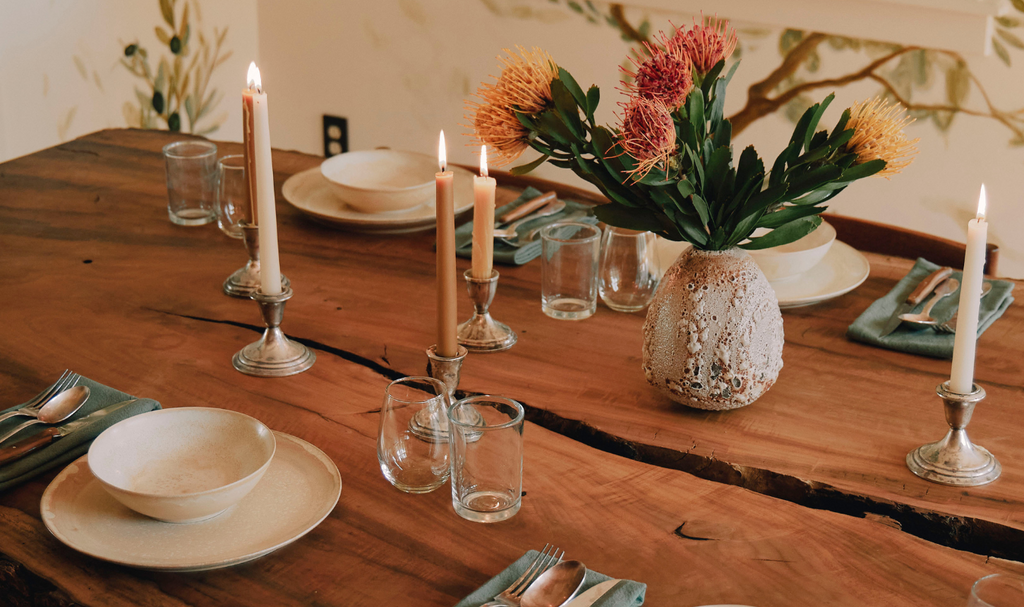 dining table with napkins, candles, and flowers