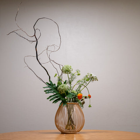 A Japanese bamboo vase with a contemporary flower arrangement